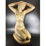 A large Lladro porcelain figure of a female nude kneeling with arms folded behind her head 'The
