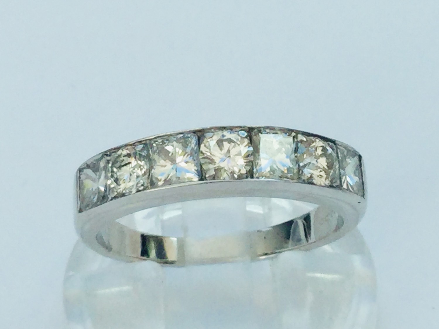 A ladies 18ct white gold diamond ring, set with four princess cut diamonds and three round brilliant