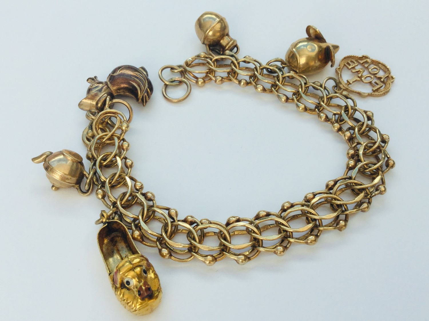 A 9ct yellow gold wire link bracelet with 6 x charms including a mouse, a duck and a teapot,