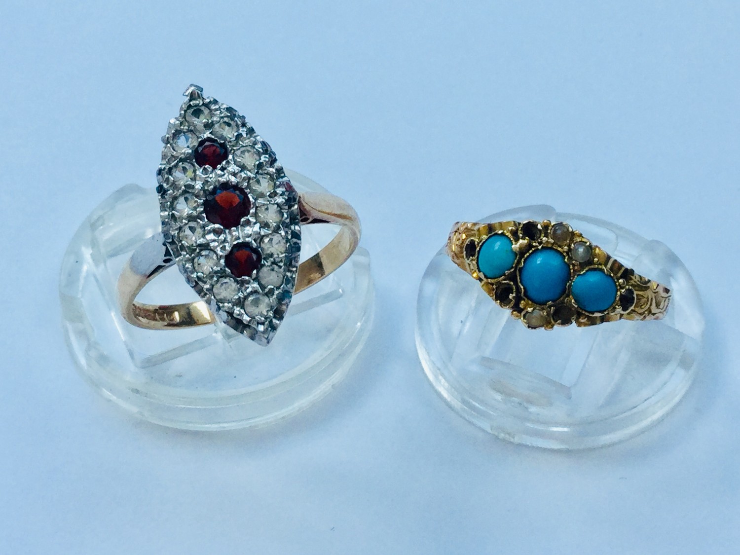 A 9ct gold Art Deco style dress ring set with 3 x round faceted red stones, surrounded by small