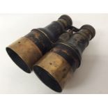 A pair of early 20th century naval binoculars, one of the sliding brass object lens shades