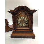 A 20th century walnut mantel clock, with domed top, arched dial with applied gilt scrolls and