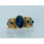 An 18ct yellow gold dress ring, set with cabochon sapphires (end sapphire missing) ring weighs 6.4