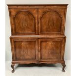 A 20th century walnut drinks cabinet, two panelled cupboard doors enclosing a shelf, above another