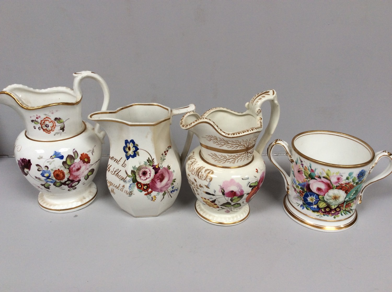 An early 19th century Staffordshire porcelain two-handled loving cup painted with roses and gilt