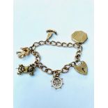 A 9ct gold curb link bracelet with five 9ct gold charms and a heart padlock fastening, charms