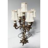 A 1950s gilt metal figural table lamp, five branches with cream shades and central column with boy