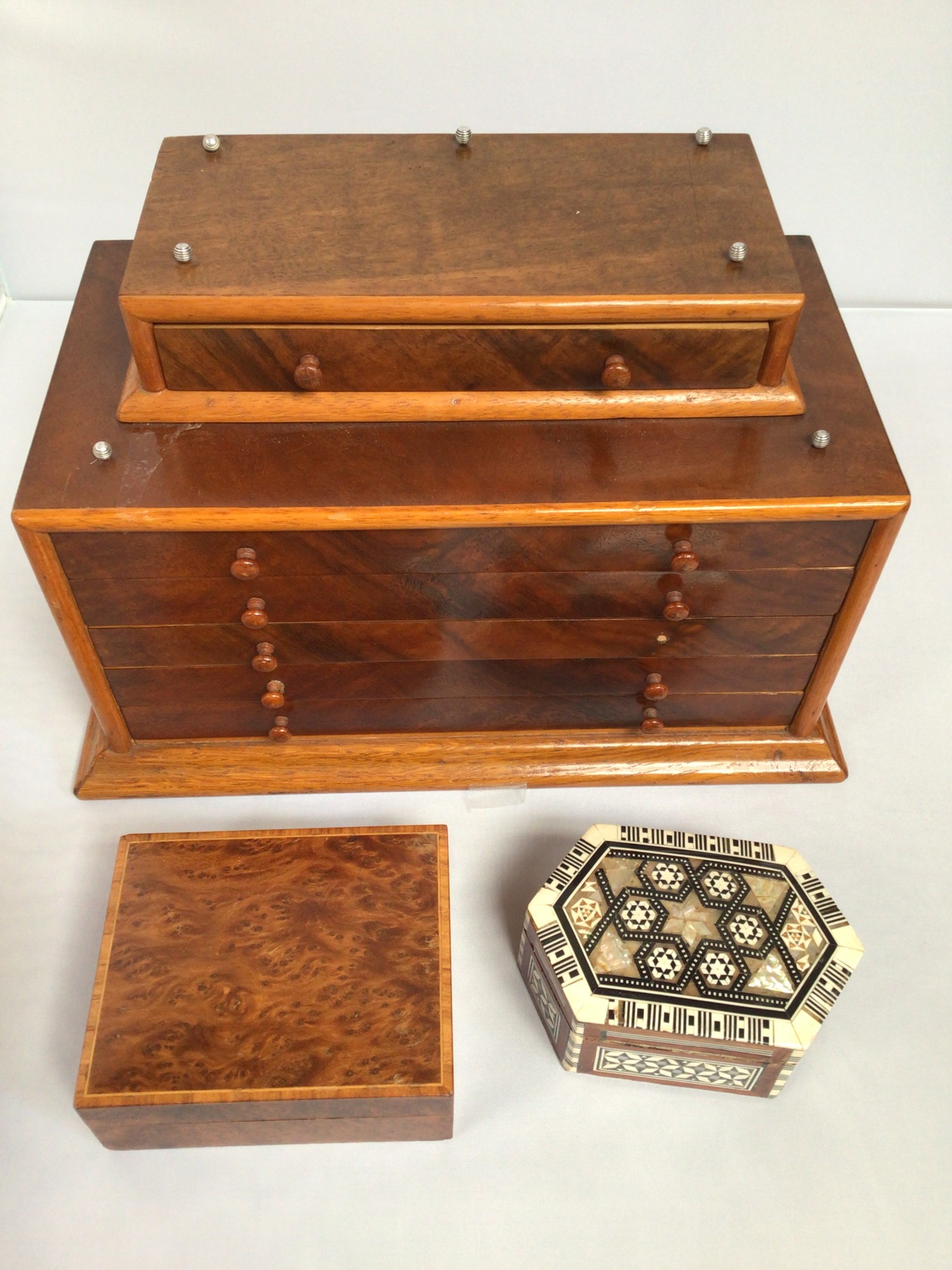 A miniature walnut veneered tabletop collector's cabinet with attached top smaller drawer above five
