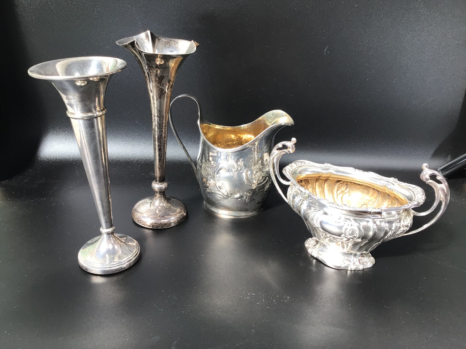 A Georgian silver embossed milk jug, marks rubbed, together with a silver twin handled sugar bowl