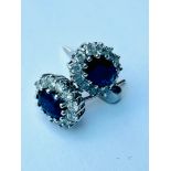 A pair of 18ct white gold sapphire and diamond cluster earrings, set with oval sapphires