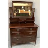 An Edwardian oak dressing table with a pivoted square mirror above a small drawer and shelf