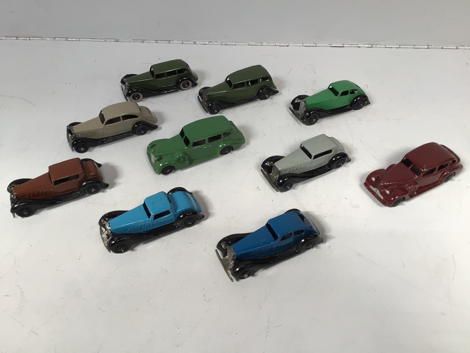 A collection of 10 assorted playworn Dinky cars including a Packard in green and a Buick in deep red