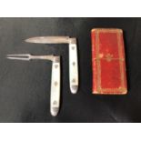 An early 19th century silver bladed and mother of pearl handled miniature knife and fork, in red and