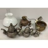 A Tibetan white metal set of graduated teapots with chains attaching covers, together with a small