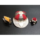 A silver pincushion in the form of a Jockey cap with red velvet cushion sections, marked 'Sterling',