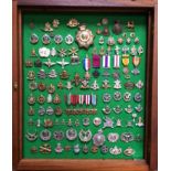 Approximately 103 military cap badges, old and new, together with various re-issue medals, in