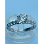 An 18ct white gold diamond ring set with a round brilliant cut diamond in a high set six claw