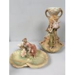 A Royal Dux porcelain figural centrepiece/nut dish, modelled as a maiden standing on a flowering