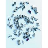A silver heavy curb link charm bracelet with 22 various silver charms including an aeroplane, a