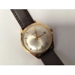A gents 9ct gold cased Garrard automatic wristwatch, the silvered dial with batons denoting hours,