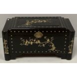 A Chinese black lacquered camphor trunk depicting a mother of pearl bird scene to the top with