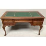 A 20th century walnut veneered desk, the top with gilt-tooled green leather scribe, above three