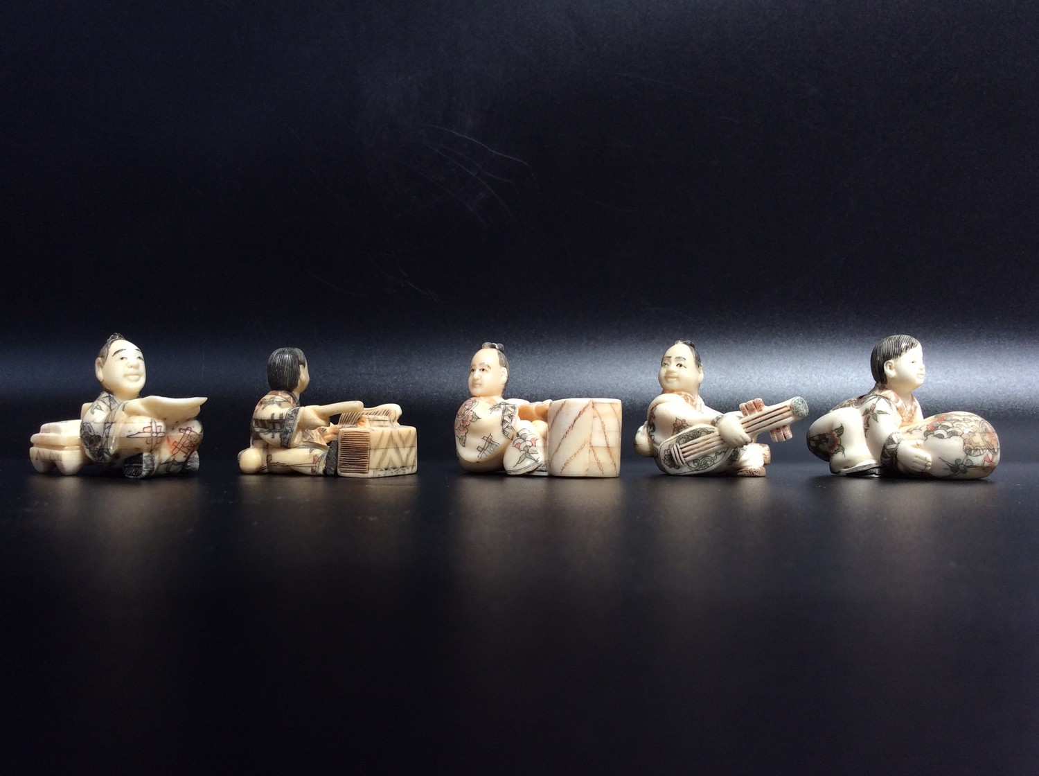 Five various Japanese carved and stained bone figural netsuke, all signed