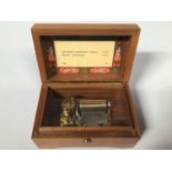 A small Swiss music box with Reuge cylinder, labeled Reuge Sainte Croix, plays songs by Mozart, 14cm