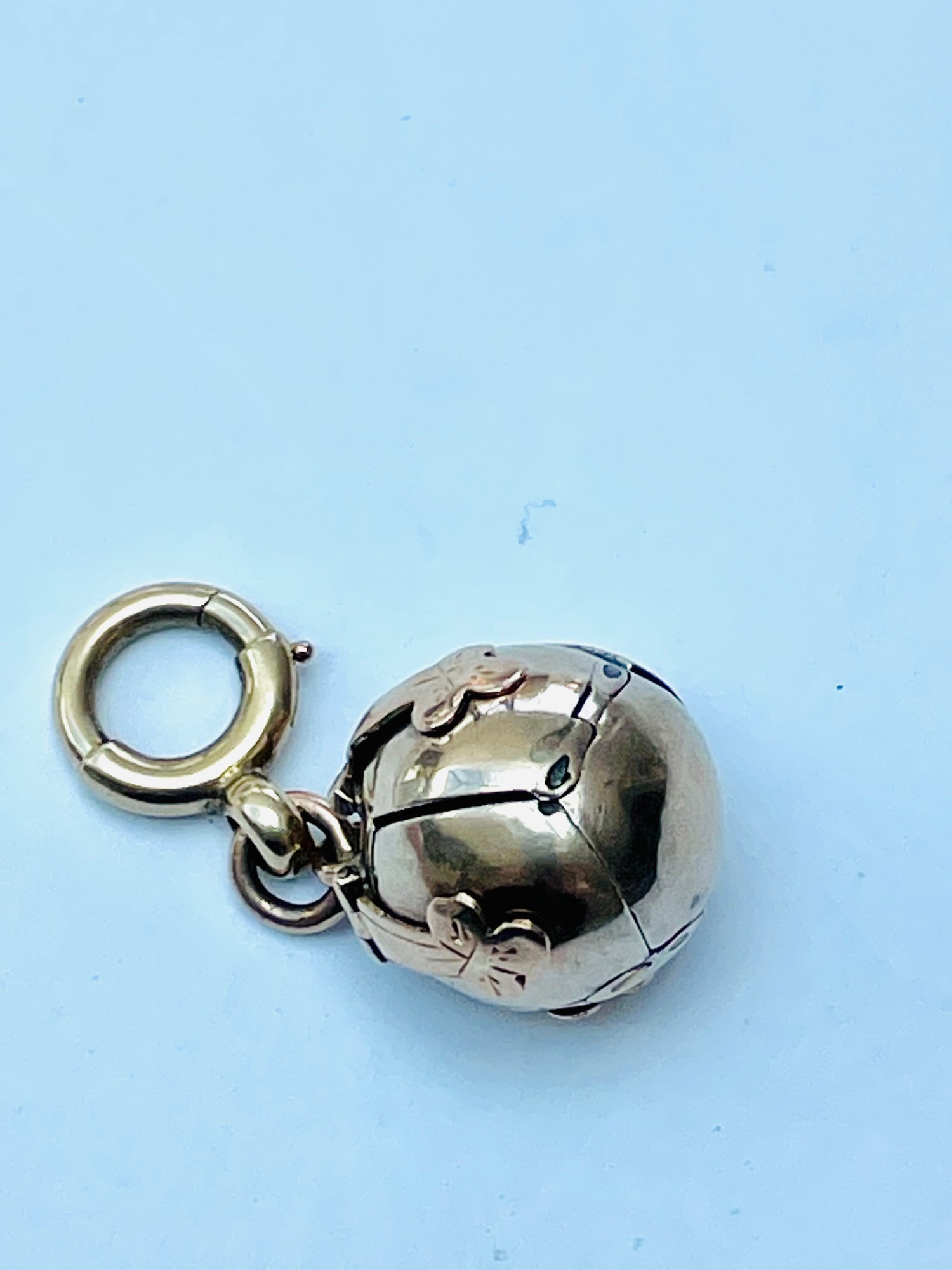 A 9ct gold and silver Masonic orb pendant, hinges open into the form of a cross, the internal