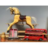 A miniature composite painted rocking horse raised on moving wooden base, 66cm long, together with a