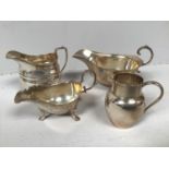 Four various items of silver comprising sauce boats and a small jug, one sauce boat by Adie Brothers