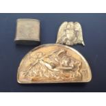 A half-moon brass belt buckle with erotic scene, together with a brass eagle clip and a brass