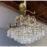 A 20th century five tier crystal chandelier with ornate decorative leaf foliate arms and brass outer