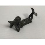 A Bergman style bronze figure of a young boy lying on his stomach smoking a pipe, underside