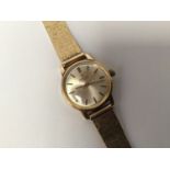 A ladies 9ct gold Omega automatic wristwatch, the silvered dial with batons denoting hours, on 9ct