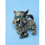 A 9ct gold terrier dog brooch with blue stone eyes, weighs 7.3 grams