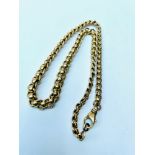 A 9ct yellow gold graduated rollerball curb chain, measuring 16 inches in length, weighs 40.7 grams.