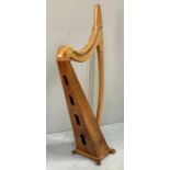 A freestanding lacquered beech and pine harp, fully strung and raised on four shaped feet, each
