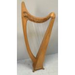 A freestanding beech and pine harp, some strings missing, raised on four shaped feet, 151cm tall