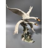A German porcelain figure group of a pair of swans in flight by Hutschenreuther, designed by Hans