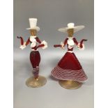 A pair of Venetian red and opaque glass figures, male and female in dancing poses with frilly neck