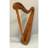 A freestanding light oak harp, with turned decoration to top, some strings missing, raised on four