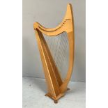 A freestanding lacquered beech and pine harp, fully strung and raised on four shaped feet, 140cm