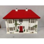 A pressed metal fronted dolls house, the front sliding open to reveal six rooms, red painted roof