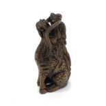 A Japanese Meji period hand carved boxwood netsuke of a seated Foo dog, signed to base with