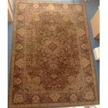 A large machine made carpet with central medallion, flowers and vases to the border, shades of