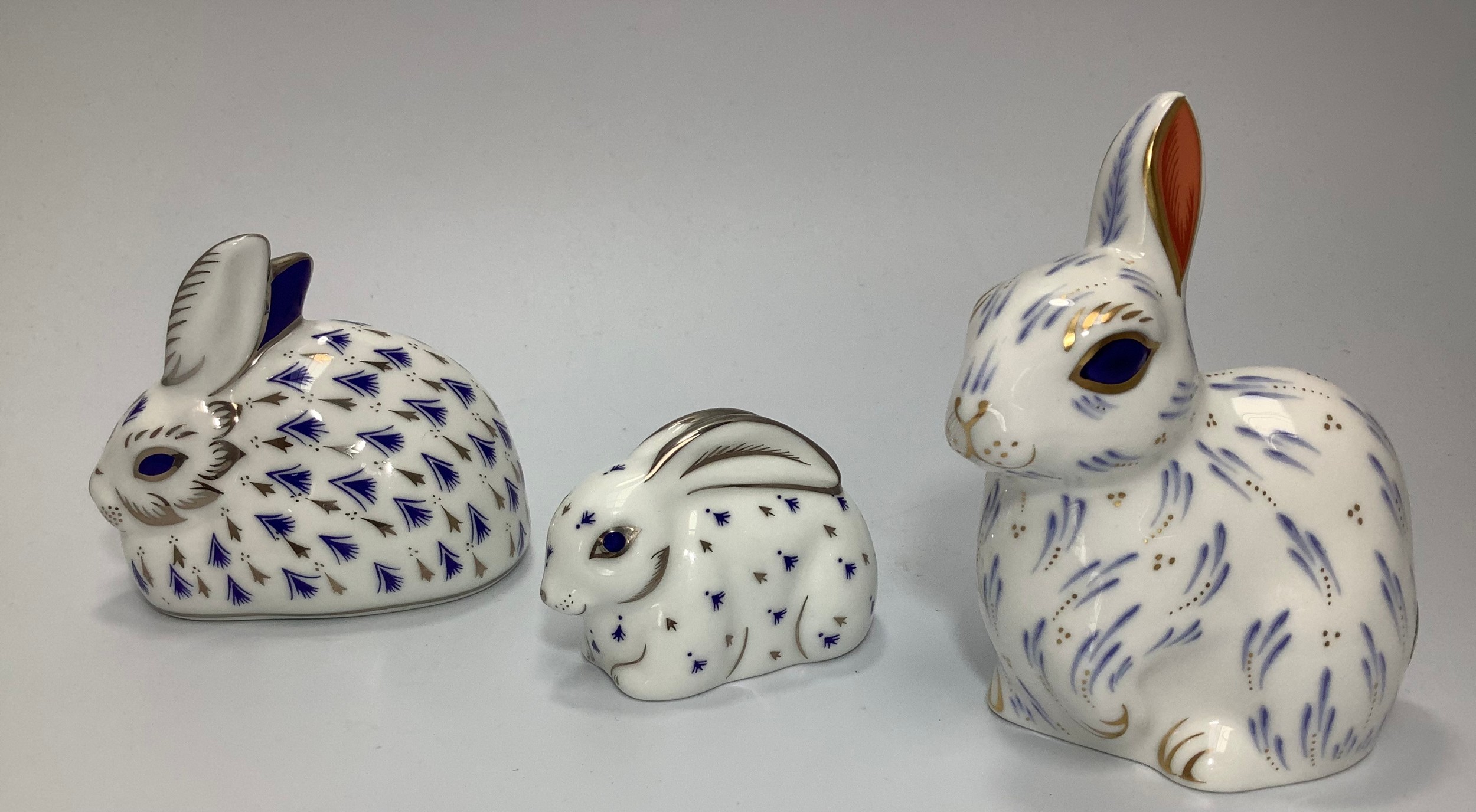 Three Royal Crown Derby paperweights, 'Snowy Rabbit' and 25th Anniversary Rabbits, 'Platinum and