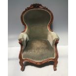 A Victorian walnut parlour chair, upholstered in green velour fabric with foliate carved back and