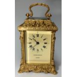 A 20th century carriage clock, of rococo design with gilded case, four bevelled glass panels and