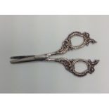 A pair of German white metal grape scissors, with decorative scrolled and floral worked silver
